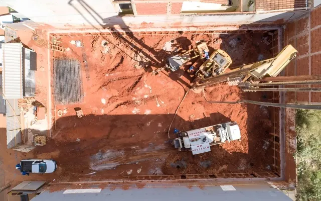 Vista aérea de escavação urbana estreita com contenção nas laterais, executada pela HR Fundações